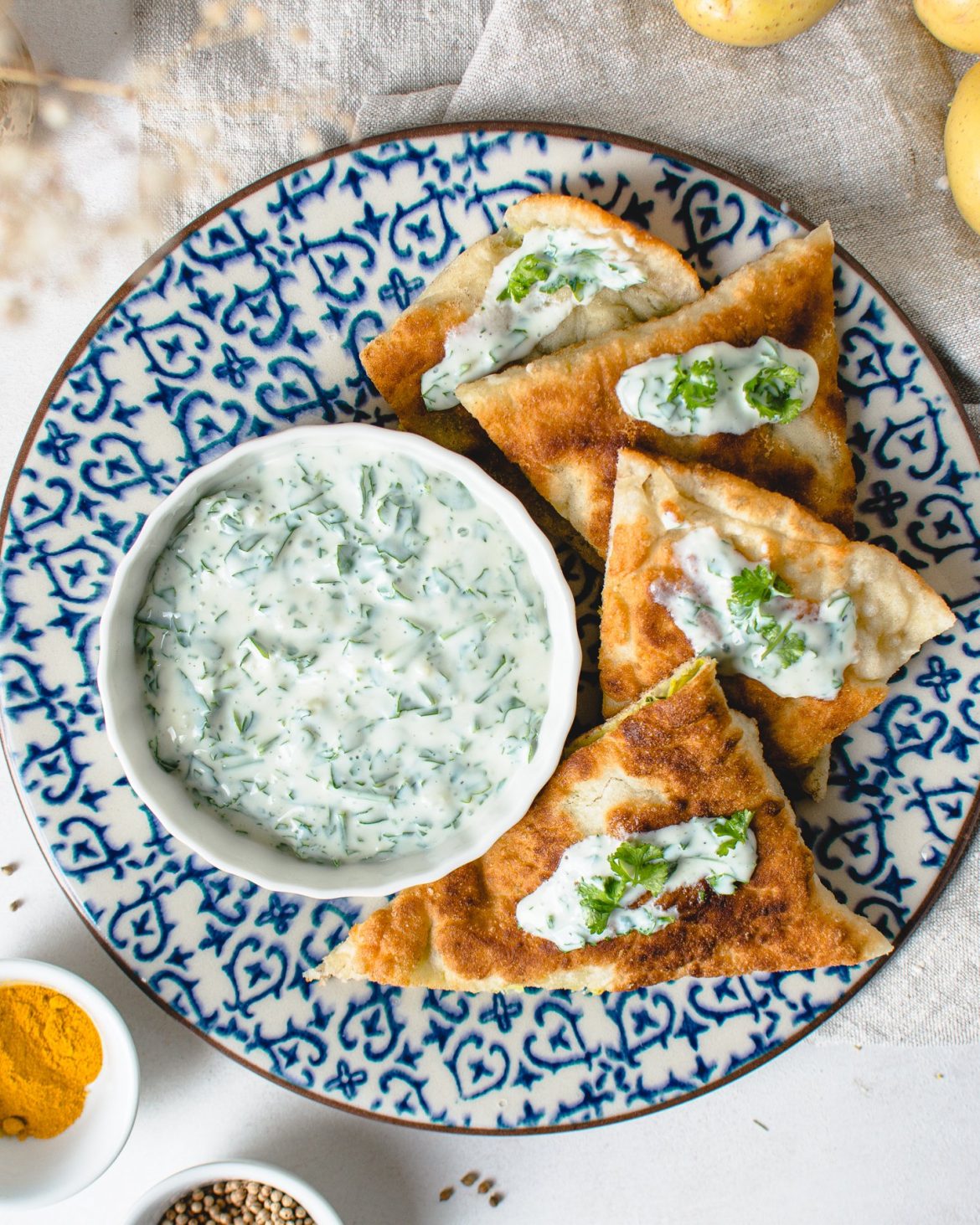 Afghanische Bolani Rezept: Gefüllte Fladenbrot mit Kartoffel-Lauch-Mischung, serviert mit Joghurt-Knoblauch Soße.